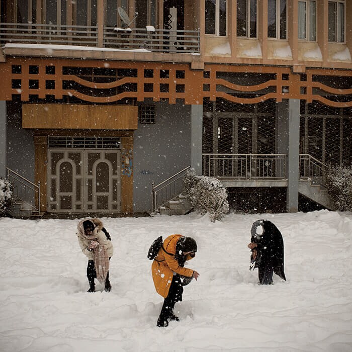 首都カブールの集合住宅の裏庭で今年2月、降り積もる雪の中遊ぶ少女たち。タリバン政権下では、男性の保護者なしに少女たちが外出したり公園に行ったりする権利は奪われた。雪嵐は少女たちにとって一緒に遊べる数少ない貴重な時間だが、タリバンの監視がいないか常に周囲への警戒は怠らない