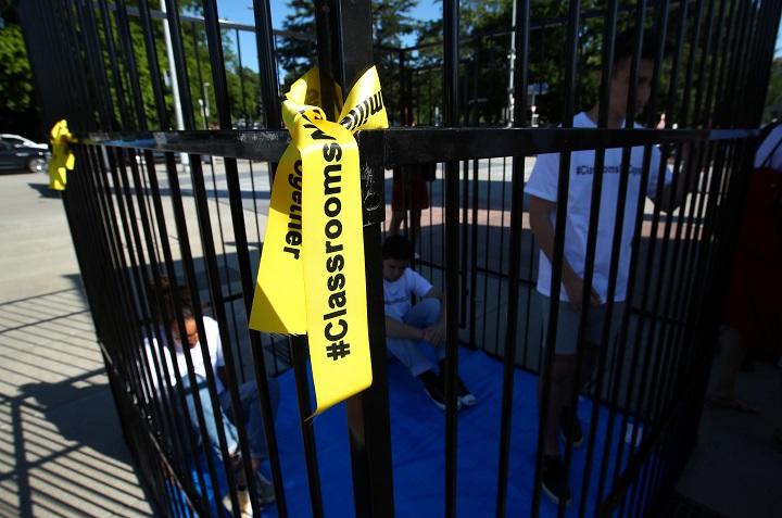 檻に入って、トランプ政権の児童移民の扱いに抗議する人々（6月17日、スイス）Denis Balibouse- REUTERS