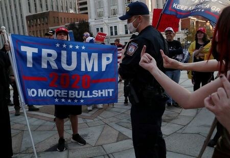 １１月２７日、 米ペンシルベニア州を管轄する連邦第３巡回区控訴裁判所は２７日、同州で民主党のバイデン候補が大統領選に勝利したとする結果の認証を巡って、差し止めを求めていたトランプ大統領の陣営による訴えを退けた。写真は１１月７日、ペンシルバニア州で対峙するトランプ氏支持者とバイデン氏支持者（２０２０年　ロイター／Leah Millis）