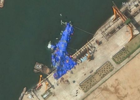　５月２６日、北朝鮮国営の朝鮮中央通信（ＫＣＮＡ）は、先週開かれた進水式で横倒し事故が発生した新型駆逐艦について、修理が行われていると伝えた。写真は清津市内で発生した事故後、ブルーシートに覆われた駆逐艦の衛星画像。２３日撮影。米衛星画像会社マクサー・テクノロジーズ提供（２０２５年　ロイター）