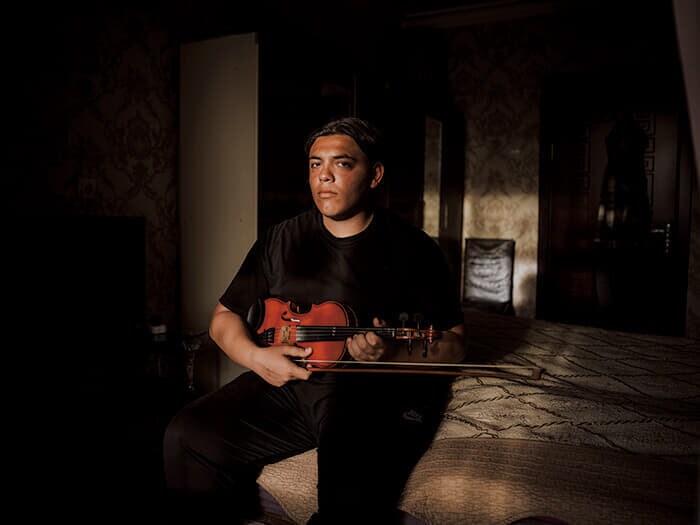 バイオリンを抱えた20歳のファクレディンは、音楽の道に進みたかったが家族から猛反対されたという。家族からは長めの髪を切れと毎日のように言われるとこぼす