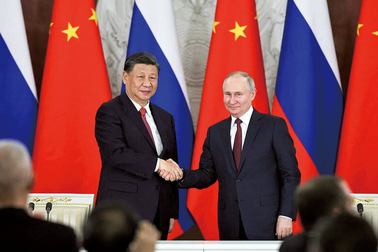 モスクワでの会談後、握手するプーチンと習近平（3月21日）　MIKHAIL TERESHCHENKOｰPOOLｰSPUTNIKｰREUTERS