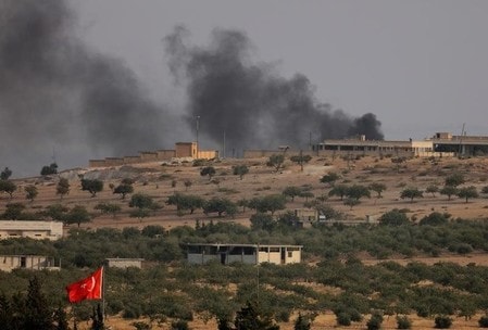 　８月２４日、トルコ軍は、シリアの反体制派武装組織の戦闘員と連携し、過激派組織「イスラム国」（ＩＳ）の支配下にあるシリア北部ジャラブルスの制圧作戦を開始した。写真は煙を上げるジャラブルス。トルコのガズィアンテプで撮影（２０１６年　ロイター／Umit Bektas）