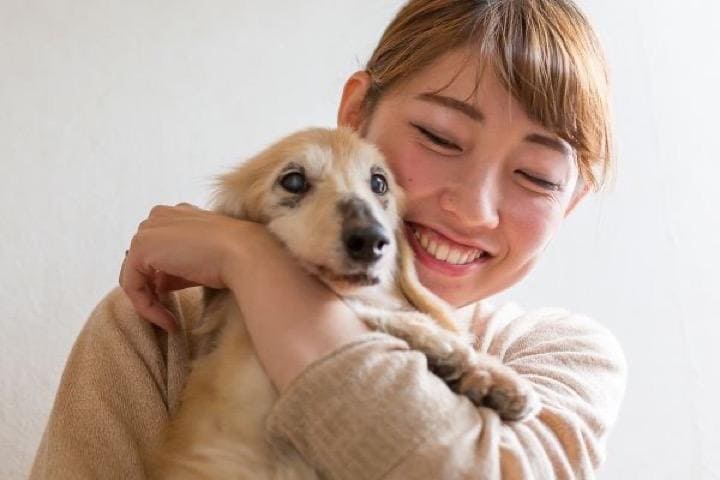 愛犬を抱きしめる女性