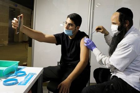 イスラエルのエーデルシュタイン保健相は２５日、人口の半数以上が新型コロナウイルスワクチンの２回目の接種を受けたと発表した。エルサレムでの接種、２月撮影。（２０２１年　ロイター/Ammar Awad）
