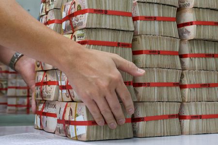 １０月１６日、 タイ中央銀行は政策金利の翌日物レポ金利を予想外に引き下げた。写真はバーツ紙幣の束。バンコクの銀行で２０２３年１月撮影（２０２４年　ロイター／Athit Perawongmetha）