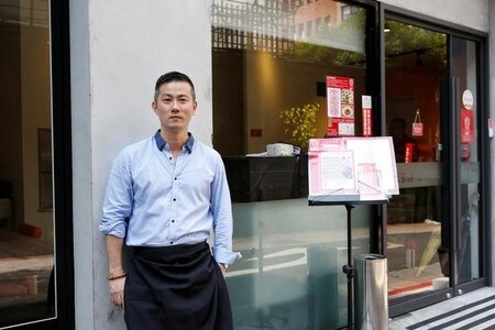 　７月１８日、今年２月に発生した香港での暴動で、デモ隊がゴミ箱に火をつけ、警官にレンガを投げ始めたとき、クリス・リー氏はきょうだいと母親を残して、台湾に移住するという自らの決断が正しかったとの確信を深めた。写真自ら開店したレストランの前に立つ香港からの移住者、クリス・リーさん。台北で１５日撮影（２０１６年　ロイター/Tyrone Siu）