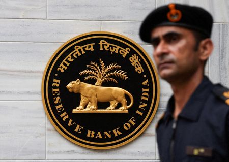 　２月１３日、インド準備銀行（中央銀行）は、国内銀行に対して適格資本の最大２０％までの買収資金融資を認めると明らかにした。写真は、インド・ムンバイの本社の外で同社のロゴの前を通り過ぎる男性。２０２５年６月撮影（２０２６年　ロイター/Francis Mascarenhas）
