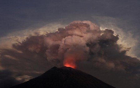 　６月２９日、インドネシア国家災害対策庁は、バリ島北東部アグン山の噴火活動が再び活発化したことによる火山灰の影響で、バリ国際空港を同日午後７時まで閉鎖すると発表した。写真は噴火するアグン山。バリで２９日撮影（２０１８年　ロイター／Johannes P. Christo）