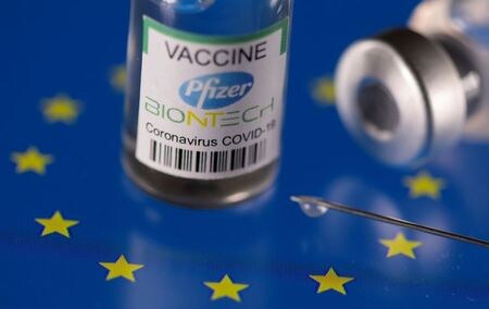 米製薬大手・ファイザーの幹部は２５日、欧州連合（ＥＵ）が域内製造の新型コロナウイルスワクチンの輸出管理を厳格化する方針を示したことに関して、誰の利益にもならない「ルーズルーズ（両者とも負け）」の状況を引き起こすと指摘した。写真は、EUフラッグの上に置かれたファイザー製のコロナワクチン。２０２１年３月２４日に撮影。（２０２１年　ロイター／Dado Ruvic）