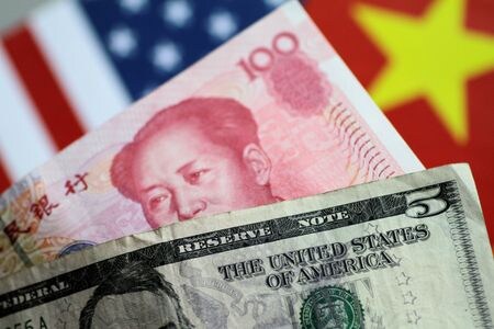 　３月２５日、中国の主要国有銀行は、人民元相場を安定させるため国内市場でドルを売って元を買っているもよう。写真は米ドルと中国元紙幣。シンガポールで２０１７年６月撮影（２０２４　ロイター／Thomas White）