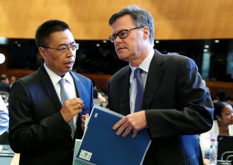 ７月２６日、２６日の世界貿易機関（ＷＴＯ）会合で、米中代表が中国の経済モデルに大きく異なる見解を示し、意見を戦わせた。ジュネーブで２６日、WTO会合前に言葉を交わす米国のデニス・シアＷＴＯ大使（右）と、中国の張向晨ＷＴＯ大使（２０１８年　ロイター/Denis Balibouse）