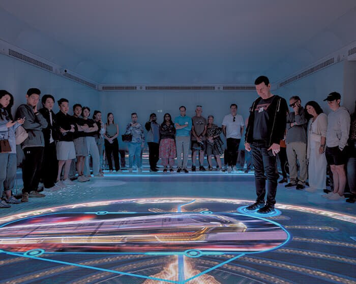 フロアに映し出された人工島パーム・ジュメイラの双方向マップのアニメーションを見つめる観光客。人工島建造の優れた建設・工学技術が紹介されるが、環境への影響などには触れない