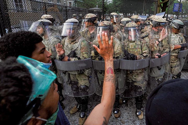 首都ワシントンで兵士に手を振るデモ参加者　KEVIN LAMARQUE-REUTERS