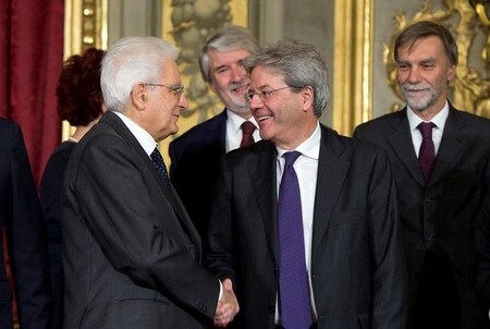 　１２月１２日、イタリアのジェンティローニ次期首相’は、マッタレッラ大統領に閣僚名簿を提出し、レンツィ政権の大半の閣僚を留任させた。金融市場の不安を払しょくする狙いがある。写真はマッタレッラ大統領（左）と握手するジェンティローニ次期首相。提供写真（２０１６年　ロイター/Handout via REUTERS）