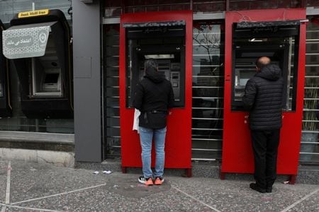 写真はATMを利用するテヘランの人々。3月10日、テヘランで撮影。WANA提供。REUTERS