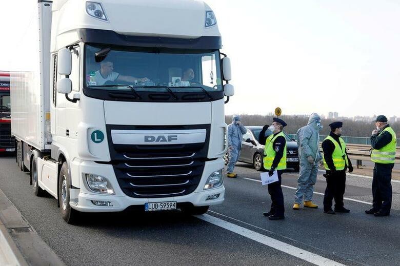 西側諸国の物流業者が陸運、海運、空運のすべてで悪戦苦闘している。写真は17日、ドイツとポーランドの国境で検温を受けるトラック運転手（2020年　ロイター/Axel Schmidt）