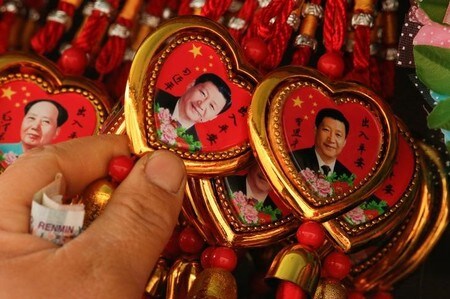 　３月１日、中国共産党機関紙の人民日報は同日付の論説記事で、国家主席の任期を撤廃する改憲案について、終身制を意味するものではないと主張した。写真は習近平国家主席の肖像をあしらった土産物のネックレス。北京で２月撮影（２０１８年　ロイター/Thomas Peter/File Photo）