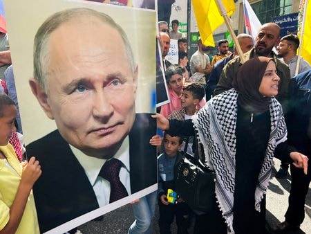 　イスラエルに対するイスラム組織ハマスの奇襲攻撃で多くの犠牲者が出たのは、ロシアのプーチン大統領の７１歳の誕生日だった。同大統領がコメントしたのは事件の３日後、非難の矛先はハマスではなく米国だった。写真はヨルダン川西岸で、デモの最中にロシアのプーチン大統領の写真を掲げる女性。１０月２０日撮影（２０２３年　ロイター/Yosri Aljamal）
