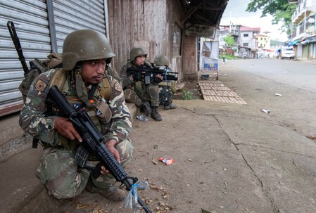 　６月１３日、フィリピン軍幹部は、過激派組織「イスラム国」（ＩＳ）系武装勢力が南部ミンダナオ島のマラウィ市の約２０％をなお支配下に置いていると明らかにした。写真はマラウィ市を警備する警察と兵士たち。７日撮影（２０１７年　ロイター）