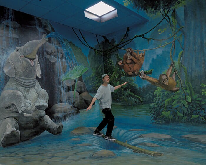 3Dトリックアート博物館の「セルフィーミュージアム」で写真の撮り方をアドバイスするスタッフ。館内には185以上の背景が設置され、観光客は想像力を発揮して撮影を楽しめるという