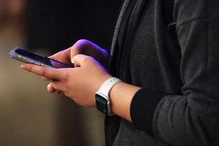 アッシャーさんが２０２２年、初めてギャンブル依存症患者の集まり「ギャンブラーズ・アノニマス」の集会に出たとき、参加者は１０数人だったが、今では６０人に増えた。写真はニューヨークで２０２２年２月、スマートフォンを使用する人（２０２４年　ロイター／Andrew Kelly）