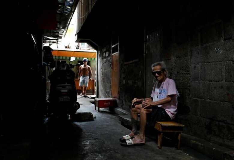 １１月２７日、警察の報告書は明快だった。フィリピン首都マニラの貧困地区で、３人の男性に麻薬取締官が発砲して負傷させ、病院に「緊急搬送」したが、運ばれた時にはすでに死亡していた、と記してある。写真は事件発生現場に座る男性。マニラで１０月１３日撮影（２０１７年　ロイター/Dondi Tawatao）