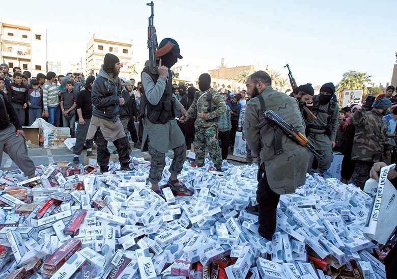 ISISの「首都」ラッカで、没収したたばこを燃やそうとする戦闘員 REUTERS