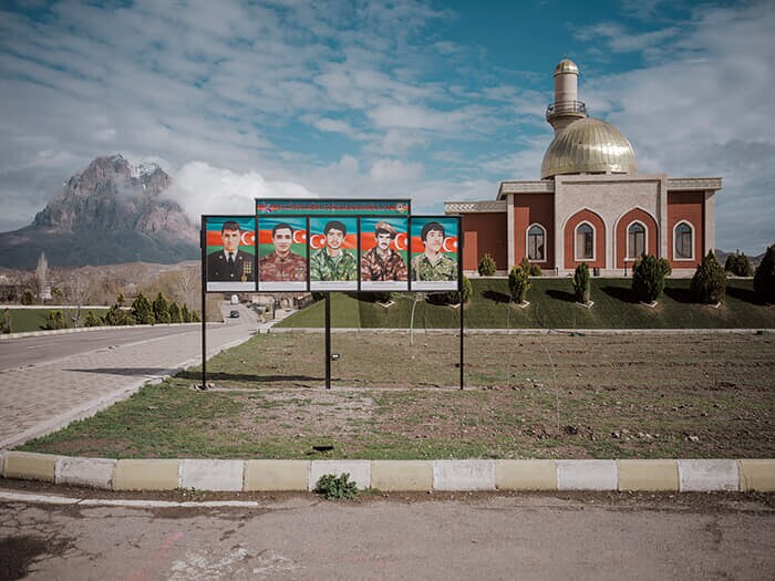 ナゴルノカラバフ紛争で命を落とした兵士の肖像写真がモスク（イスラム礼拝所）の前に掲げられている