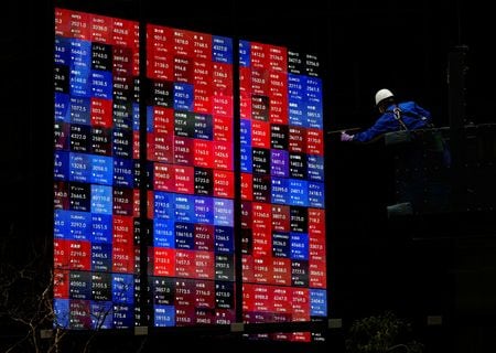 　２月２１日、 日経平均株価が史上最高値に迫る中、米エヌビディアの決算を前に、半導体関連株の上昇に一服感が出ている。写真は１９日、都内の株価ボード前で撮影（２０２４年　ロイター/Issei Kato）