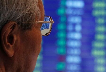 　７月１日、前場の東京株式市場で、日経平均は前営業日比４１円９４銭安の２万２２４６円２０銭となり、小反落した。写真は株価ボードを見る人。２０１３年６月、都内で撮影（２０２０年　ロイター／Issei Kato）