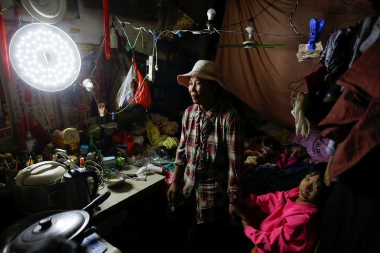 １０月１５日、中国の習近平国家主席は、２０２０年までに極度の貧困を解消するというキャンペーンを実施しているが、都市移住者たちは取り残されている。写真は、北京に移り住み、スクラップ回収で生計を立てている５９歳のWang Qinさんと１０歳の孫娘。自宅で１日撮影（２０１７年　ロイター/Thomas Peter）