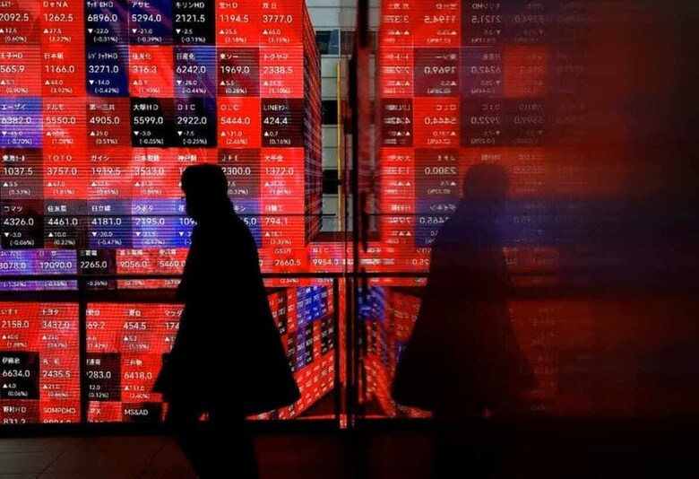 １０月２２日、グローバルに運用されている資金が再び日本に流入しつつある。写真は２０２４年２月、都内の株価ボードで撮影（２０２５年　ロイター/Issei Kato）