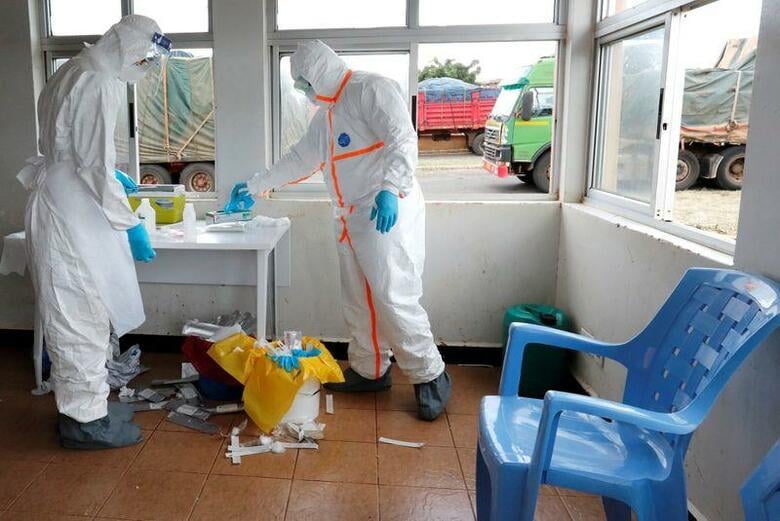 新型コロナウイルスの検査数など信頼できるデータの不足はアフリカ諸国の多くに共通する問題だ。トラック運転手の検査を準備するケニア衛生当局の医療従事者。5月12日、ケニアとタンザニアの国境で撮影(2020年　ロイター/Thomas Mukoya)