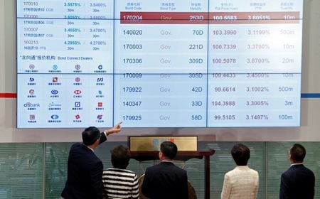 Guests check a panel displaying bond trading during the launching ceremony of Bond Connect at Hong Kong Exchanges in Hong Kong, China July 3, 2017.      REUTERS/Bobby Yip - RC1565D592D0