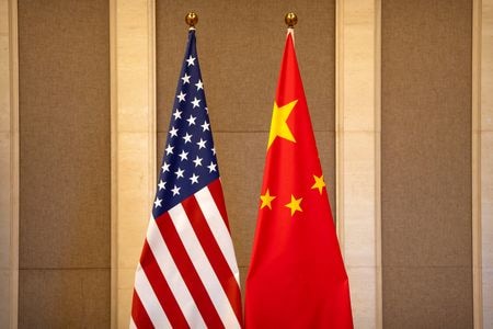 中国の王毅外相は、習近平国家主席とバイデン米大統領の会談について、包括的で踏み込んだ「非常に好ましい」会談だったと述べた。写真は米中両国の国旗。北京で７月撮影。（2023年 ロイター/Mark Schiefelbein/Pool via REUTERS/File Photo)