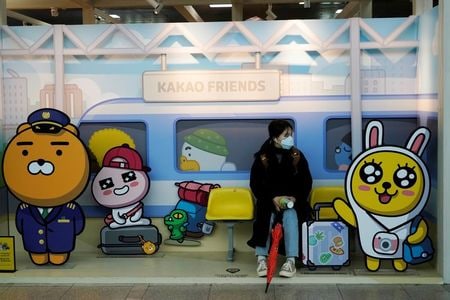 　２月２６日、韓国疾病予防管理局（ＫＣＤＣ）は、新型コロナウイルスの国内の感染者が１６９人増えて１１４６人になったと発表した。写真はソウルの駅の写真スポットに座る、マスクをつけた女性。２５日撮影（２０２０年　ロイター/Kim Hong-Ji）