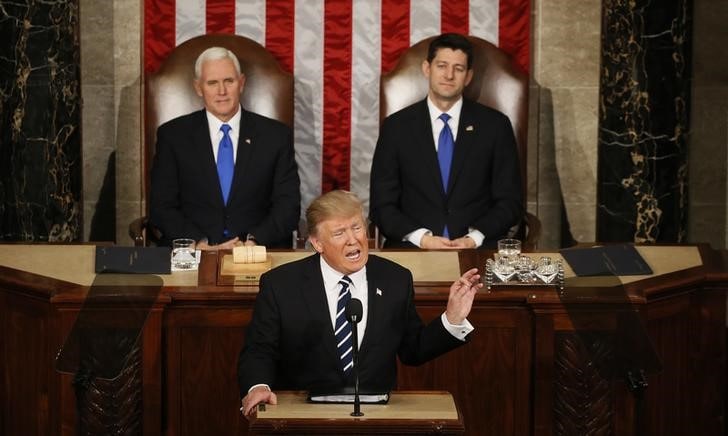 ２月２８日、トランプ米大統領は、上下両院合同会議で演説し、幅広い移民制度改革に言及したほか、中間層向けの大幅な税負担軽減や法人税減税を実施すると表明した。写真は演説する同大統領（中央）。ワシントンで撮影（２０１７年　ロイター/Jim Bourg）