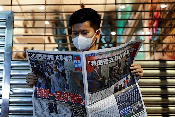 中国共産党に批判的な論調で知られる香港紙・蘋果日報(アップル・デイリー)は、創業者の黎智英(ジミー・ライ)氏の逮捕から一夜明けた11日、1面に「アップル・デイリーは戦わなければならない」との見出しを立て、警察に連行される黎氏の写真を掲載した。写真は香港で11日撮影(2020年　ロイター/TYRONE SIU)