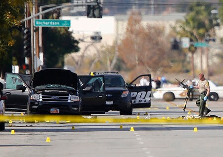 　１２月４日、米ＦＢＩ幹部は、カリフォルニア州サンバーナディーノの福祉施設で発生した銃乱射事件について、「テロ行為」として捜査を進めていることを明らかにした。写真は容疑者が射殺された付近の捜査現場から銃を運ぶ警察官。３日撮影（ロイター/Mike Blake）