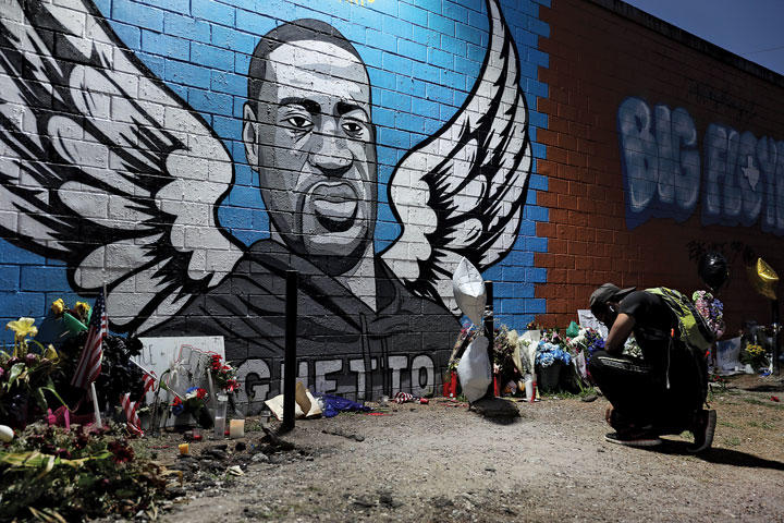 ヒューストンの第3区にある建物の壁に設けられたフロイドの追悼の場で祈る　JOE RAEDLE/GETTY IMAGES