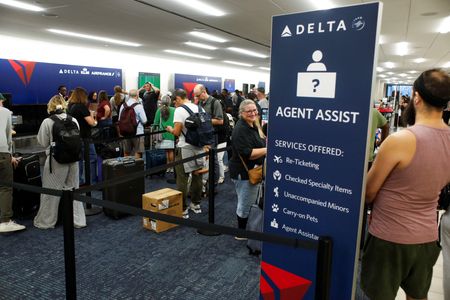 米デルタ航空は、１９日に発生した世界的なシステム障害で欠航などによって生じた損害を巡り、マイクロソフトと米サイバーセキュリティ―企業クラウドストライクに対して補償を求める意向で、法律事務所と契約した。ＣＮＢＣテレビが２９日、報じた。写真は空港のチェックインカウンターで待つ利用者。７月１０日、フロリダ州タンパで撮影（２０２４年　ロイター/Octavio Jones）