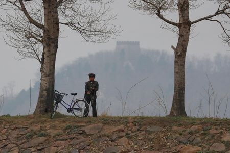 　１０月３１日、韓国を拠点とする人権団体「転換期正義ワーキンググループ」は、脱北を試みたり韓国の親族に電話をかけようとした北朝鮮人１００人以上が国家保衛省（秘密警察）に身柄を拘束された後に行方が分からなくなっているとの報告書をまとめた。写真は中国との国境付近で監視を行う北朝鮮兵。２０１７年４月、新義州市鴨緑江で撮影（２０２４年　ロイター/Aly Song）