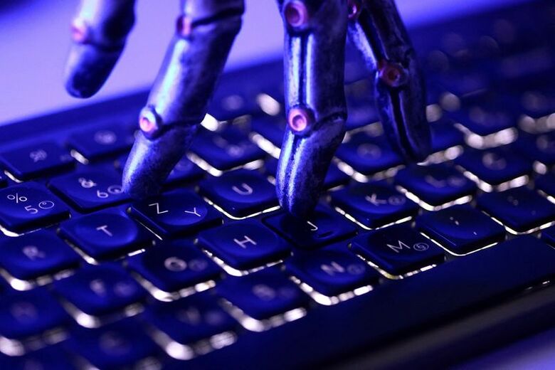 写真はロボットの手とキーボードのイメージ。6月5日撮影。REUTERS/Dado Ruvic
