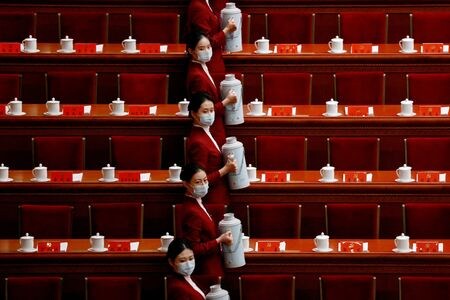 　１０月１８日、習近平党総書記（国家主席）の３期目続投が確実視されている開催中の中国共産党第２０回党大会で、ジェンダー平等の推進に期待する中国人女性はほとんどいない。写真は党大会の開会式前に出席者にお茶を準備する係員。１６日、北京にある人民大会堂で撮影（２０２２年　ロイター/Thomas Peter）