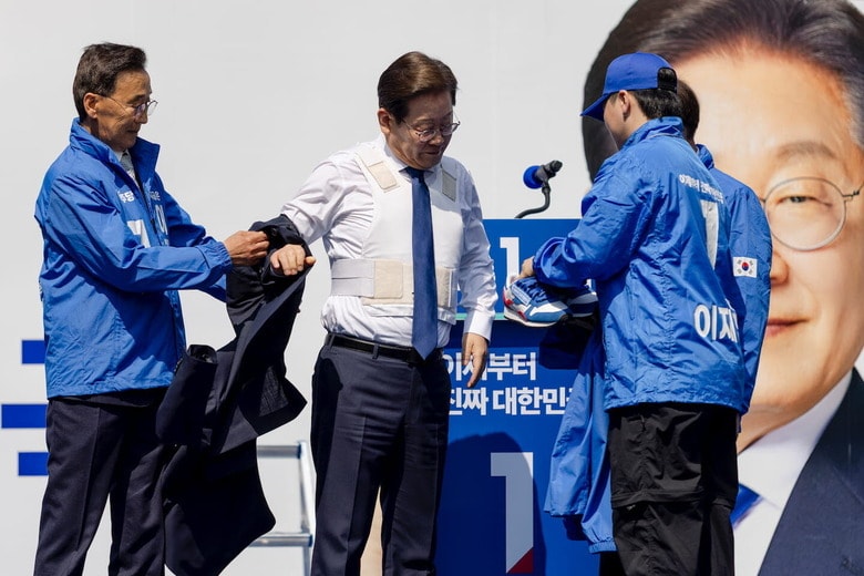 選挙運動初日の舞台でReebokのスニーカーに履き替えるイ・ジェミョン　Chris Jung-NurPhoto-Reuters