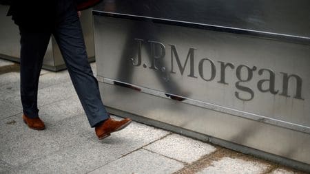 FILE PHOTO: A man walks into the JP Morgan headquarters at Canary Wharf in London May 11, 2012.  REUTERS/Dylan Martinez/File Photo