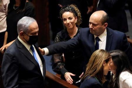 イスラエル国会は、右派政党「ヤミナ」のベネット党首（右）が率いる連立政権を承認し、歴代最長の１２年続いたネタニヤフ政権（左）に終止符が打たれた（２０２１年　ロイター／Ronen Zvulun）