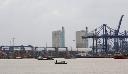 　１２月１１日、ベトナム国会は、精製レアアース（希土類）輸出を制限し、鉱石輸出禁止を改めて規定した改正法を承認した。写真は、ベトナム・ホーチミン市のコンテナ港前で魚を捕る男性。２０１８年７月撮影（２０２５年　ロイター/Kham）