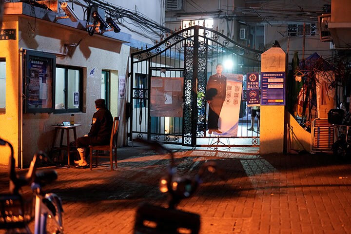 封鎖された住宅エリアの門には、大きな警官のパネルも（4月11日、上海）　Aly Song-REUTERS